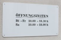 Fotografie eines Schildes mit Ladenöffnungszeiten
